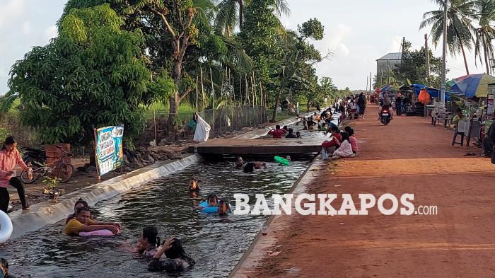 BERENANG – Sejumlah masyarakat ketika berenang di Pemandian Irigasi Viral Aik Item Desa Rias, Jumat (26/6/2026).  Pemandian tersebut kini mulai ramai diserbu pengunjung selama satu bulan terakhir.