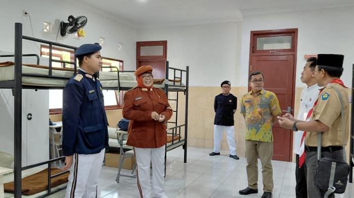 ASRAMA SISWA - Kepala Sekolah Rakyat Menengah Pertama (SRMP) 13 Kabupaten Banyumas, Siti Isbandiyah (jas merah marun), menunjukkan asrama tempat tinggal peserta didiknya, Senin (19/6/2026). Sekolah Rakyat Banyumas menyediakan asrama bagi 50 siswa angkatan pertama, serta asrama bagi guru dan tenaga pendidik.