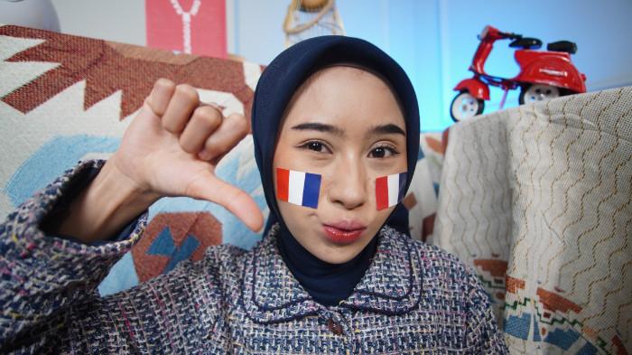 Wanita asal Karanganyar mengenakan stiker Prancis di wajah sebagai bentuk dukungan dalam Piala Dunia 2026, di Kota Solo, Jawa Tengah, Senin (15/6/2026).