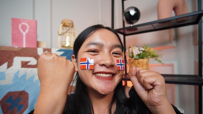Wanita asal Blora mengenakan stiker Norwegia di wajah sebagai bentuk dukungan dalam Piala Dunia 2026, di Kota Solo, Jawa Tengah, Senin (15/6/2026).(Tribun-Video.com/Akmal Khoirul Habib)