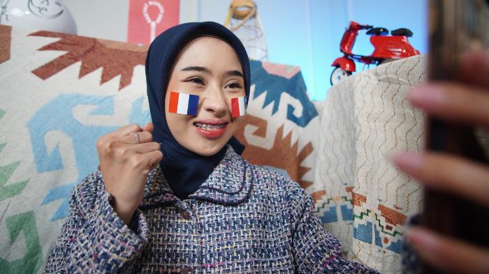 Wanita asal Karanganyar mengenakan stiker Prancis di wajah sebagai bentuk dukungan dalam Piala Dunia 2026, di Kota Solo, Jawa Tengah, Senin (15/6/2026). (Tribun-Video.com/Akmal Khoirul Habib)