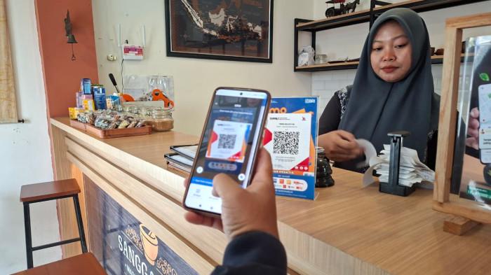 QRIS BRI - Pembeli saat bertransaksi melalui QRIS BRI di Kafe Jamu Sangga Ramu Kecamatan Nguter, Kabupaten Sukoharjo.
