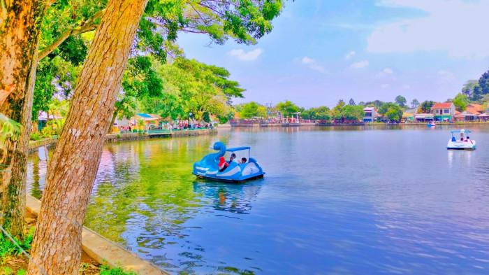 WISATA BOGOR – Suasana tenang tempat wisata Situ Gede Bogor terlihat menyejukkan dengan pemandangan air yang jernih dan pepohonan rindang di sekitarnya.