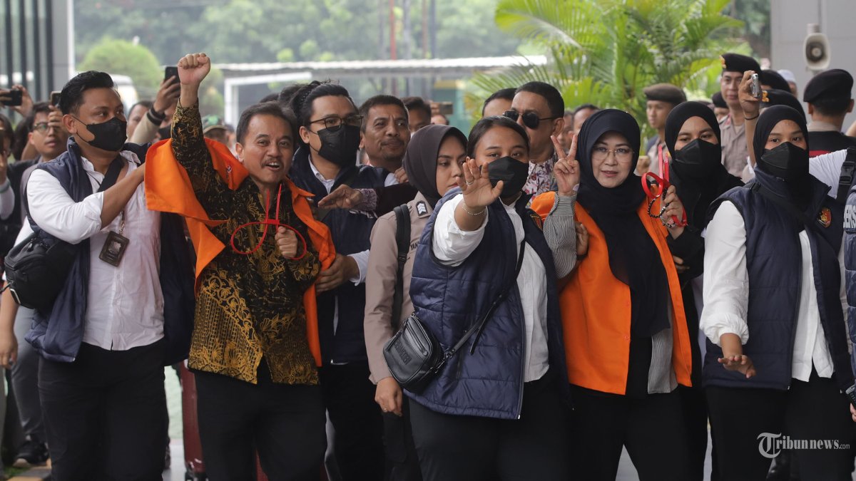 PELIMPAHAN BERKAS - Petugas kepolisian menggiring Roy Suryo bersama Tifauzia Tyassuma ke dalam gedung di Kejaksaan Negeri Jakarta Selatan, Jakarta, Senin (22/6/2026). Polda Metro Jaya resmi melimpahkan tersangka beserta barang bukti dugaan fitnah ijazah palsu Presiden ke-7 RI Joko Widodo (Jokowi), yakni Roy Suryo dan Tifauzia Tyassuma ke Kejaksaan Negeri (Kejari) Jakarta Selatan. Tribunnews/Jeprima