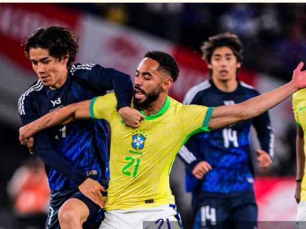 Ao Tanaka (kiri) berebut bola dengan Matheus Cunha dalam laga uji coba Timnas Jepang melawan Brasil di Tokyo (14/10/2025). Kedua tim akan bertemu lagi di babak 32 besar Piala Dunia 2026.