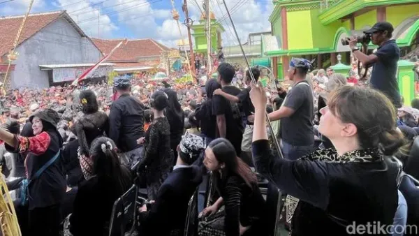 Lara Cummings tampak mengabadikan momen kemeriahan tradisi Kebo-keboan Alasmalang Banyuwangi.