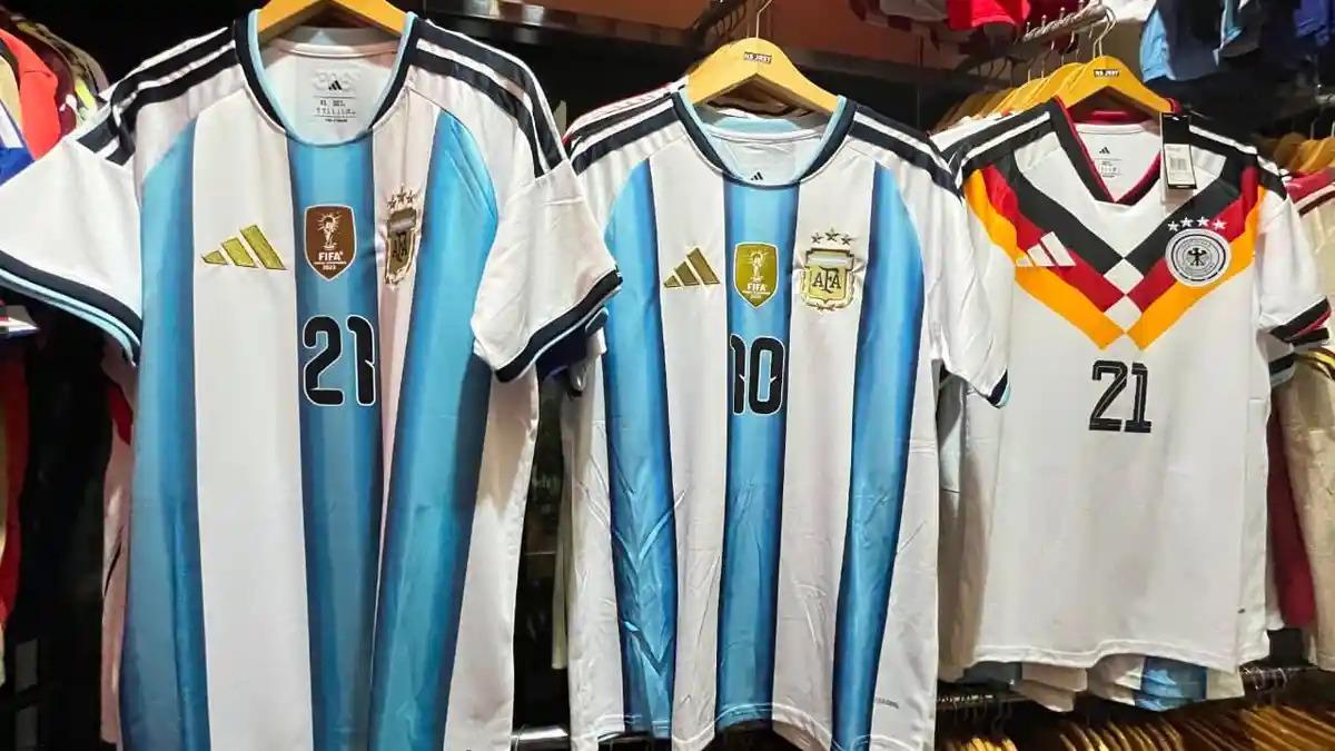SAMBUT PESTA BOLA - Nofi Setiawan penjual jersey negara yang berlaga di Piala Dunia 2026 sedang memamerkan barang dagangannya di Mojosongo, Solo, Rabu (10/6/2026). Update ranking FIFA 48 peserta Piala Dunia 2026, Argentina kukuh di puncak, Ghana naik signifikan.