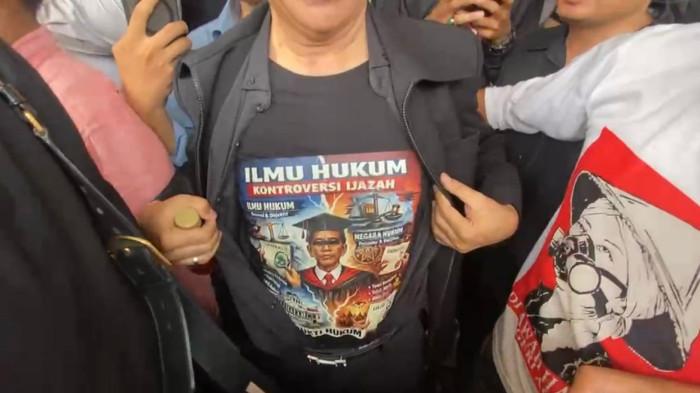 SIDANG PRAPERADILAN - Momen Roy Suryo saat tunjukan baju bergambar mirip Jokowi usai hadiri sidang perdana Praperadilan yang dia ajukan di Pengadilan Negeri Jakarta Selatan, Senin (29/6/2026). Meski begitu dalam momen itu, Roy tidak menjelaskan makna spesifik dari kaos bergambar pria mirip Jokowi yang dirinya kenakan.