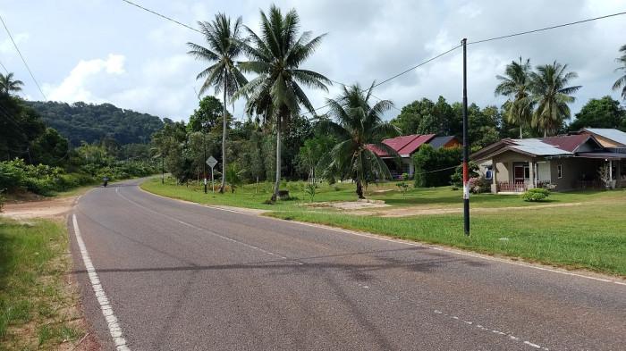 DESA BURONG MANDI - Jalan utama di Desa Burong Mandi, Belitung Timur, membelah kawasan permukiman yang dikelilingi perbukitan hijau dan pantai. (Bangkapos.com/Andini Dwi Hasanah).