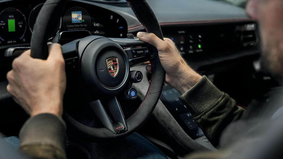 hands gripping a sporty steering wheel in a modern car interior