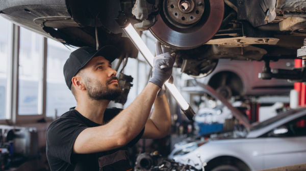 A mechanic inspecting a car's suspension