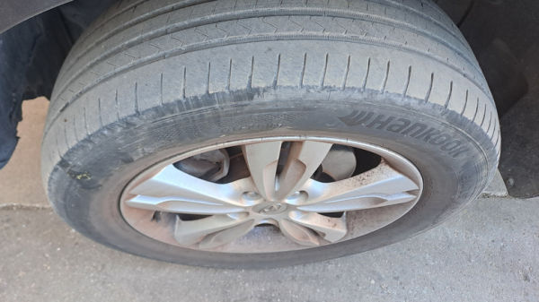 Top-down view of a dirty car tire with worn-out tread.