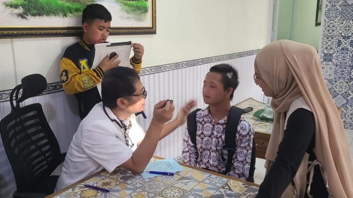 Dokter  I Nyoman Arya sedang memeriksa penerima manfaat pemeriksaan kesehatan