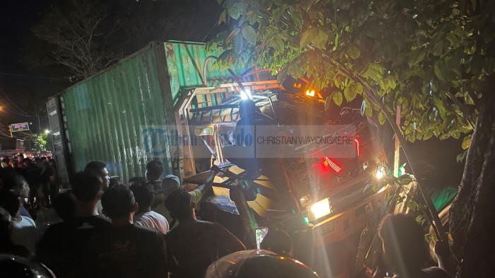 LAKALANTAS - Kondisi mobil bertonase besar, Mitsubishi Fuso truk tronton warna orange angkut peti kemas Spil warna hijau dengan nomor polisi DB 8263 QC pada peristiwa lakalantas di jalan Wolter Monginsidi Kelurahan Wangurer Barat Kecamatan Madidir Kota Bitung, Selasa (30/6/2026) malam. Warga berkerumun menyaksikan.
