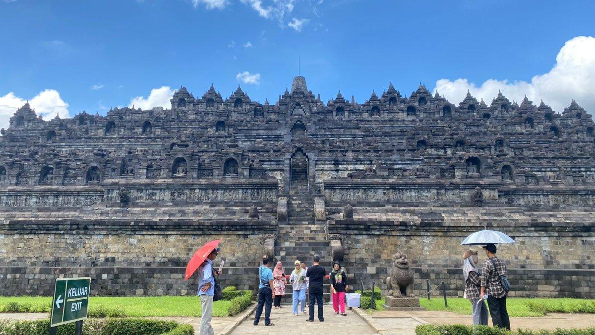 Wisatawan berfoto dengan latar Candi Borobudur dari pelataran, Sabtu (4/3/2023). 