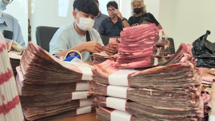 MENGHITUNG - Petugas dari BI Tegal saat melakukan penghitungan uang rusak sebesar Rp 1,54 miliar milik dr Ida yang rusak akibat terendam rob, pada Kamis 2 Juli 2026.