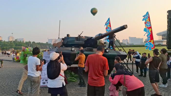 ALUTSISTA - Warga berfoto di Tank Leopard 2 dan Komando Cadangan Strategis Angkatan Darat (Kostrad) yang digelar di Lapangan Silang Monumen Nasional (Monas) Jakarta Pusat hari ini, Minggu (5/7/2026). 