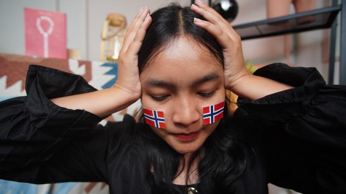 Wanita asal Blora mengenakan stiker Norwegia di wajah sebagai bentuk dukungan dalam Piala Dunia 2026, di Kota Solo, Jawa Tengah, Senin (15/6/2026).
