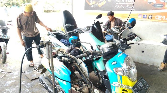 BONGKAR MESIN – Seorang mekanik membongkar mesin motor di Jalur Dua Benteng, Desa Tobadak, Kecamatan Tobadak, Kabupaten Mamuju Tengah, Sulawesi Barat, akibat diduga menggunakan oli palsu, Senin (26/5/2025).