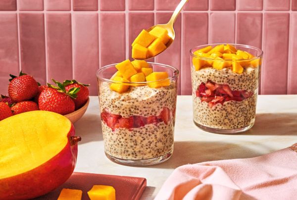 Chia pudding in glasses layered with fruit topped with mango chunks with strawberries and mango on the side Credit: Ali Redmond