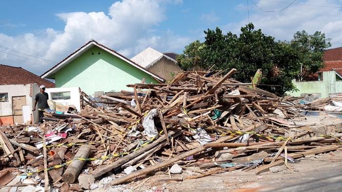 NORMALISASI - Warga tengah melintas di depan bangunan rumah yang terdampak proyek normalisasi sungai Cikunten, yang berada di Jalan Saguling, Kampung Ngamplang RT 03/13, Kelurahan Karsamenak, Kawalu, Kota Tasikmalaya, Selasa (7/7/2026).