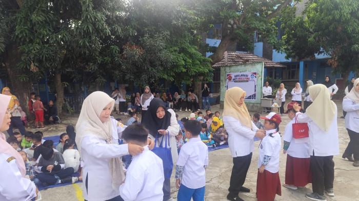 PEMASANGAN SERAGAM SEKOLAH - Dewan guru melakukan pemasangan seragam merah putih beserta atribut secara simbolis kepada perwakilan siswa kelas 1A hingga 1D sebagai tanda bahwa mereka resmi menjadi bagian dari keluarga besar SD Negeri 157 Palembang, Rabu (8/7/2026).