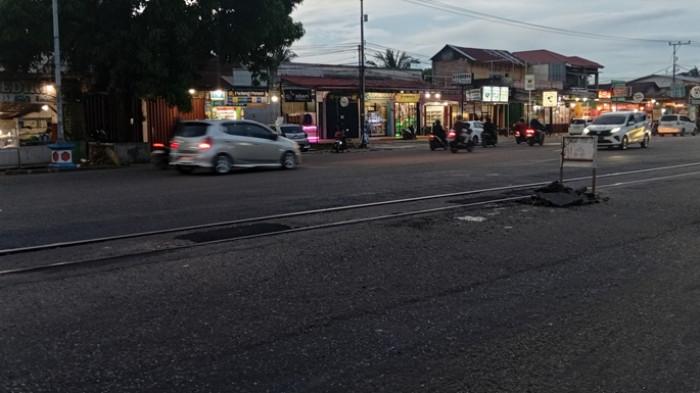 PERLINTASAN REL DIPERBAIKI – Kendaraan melintas di perlintasan kereta api Jalan Adinegoro, Kelurahan Lubuk Buaya, Kecamatan Koto Tangah, Kota Padang, Kamis (9/7/2026). Belasan lubang yang sebelumnya menganga di sela-sela rel dan sempat viral karena menyebabkan banyak pengendara sepeda motor terjatuh telah ditambal menggunakan aspal untuk mengurangi risiko kecelakaan.