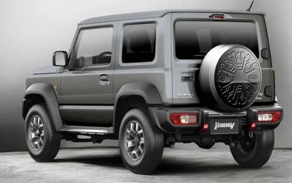 Gray Suzuki Jimny compact SUV with spare tire mounted on the rear door, shown from the back side.