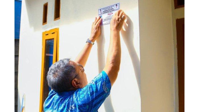 Wali Kota Tangerang Selatan Benyamin Davnie memasang stiker di rumah warga yang mendapat program bedah rumah. 
