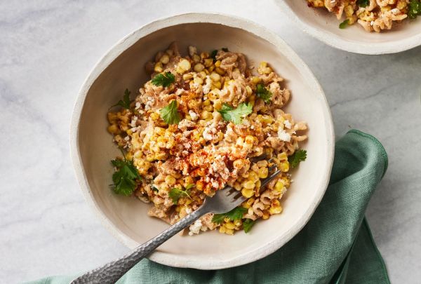 Overhead view of a bowl of Elote-Inspired Pasta Salad recipe with a fork Credit: Photographer: Greg DuPree, Food Stylist: Anna Kelly, Prop Stylist: Christina Brockman