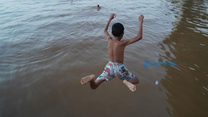 FENOMENA ANAK KOIN - Tampak anak-anak sedang melompat ke Sungai Kapuas, di Kelurahan Benua Melayu Laut, Kota Pontianak, Sabtu, 11 Juli 2026. Mereka berenang mendekati kapal demi uang.
