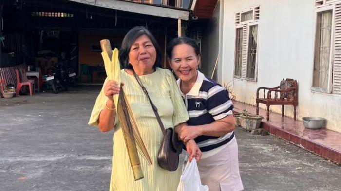 WARGA - Non Kalumata (kenakan gaun kuning) bersama keponakan Aneke Rantung (kenakan kaos hitam-putih) saat bawa pulang ole-ole dodol dan nasi jah di momen pengucapan syukur Desa Kapoya, Minsel, Minggu (12/7/2026).