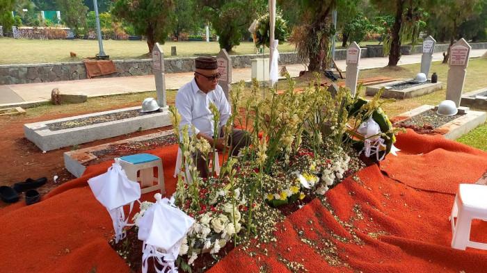 PESAN MENDALAM -- Bupati Gorontalo, Sofyan Puhi, duduk di depan makam Rachmat Gobel. Bupati menuliskan ungkapan rasa kehilangan di media sosial Facebook pada Sabtu (11/7/2026). (Sumber: Facebook Sofyan Puhi)