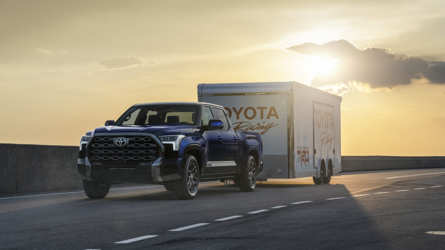 2026 Toyota Tundra towing a trailer on a highway at sunset.