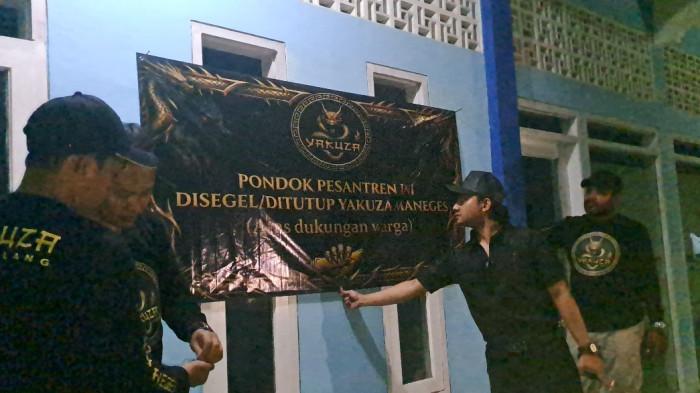 PONDOK DISEGEL - Yakuza Maneges menyegel pondok pesantren milik oknum kiai yang diduga mencabuli santrinya di Kecamatan Bululawang, Kabupaten Malang, kemarin Sabtu (13/6/2026). Penyegelan dilakukan setelah Yakuza Maneges membawa terduga pelaku ke Polres Malang. 