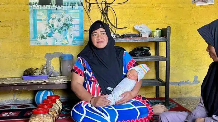 NAMA UNIK - Yuharni memperlihatkan putra ketiganya yang diberi nama Muhammad MBG Subianto di rumahnya di Dusun Prigi, Desa Jolontoro, Kecamatan Sapuran, Kabupaten Wonosobo, Jawa Tengah, Senin (13/7/2026). Nama tersebut dipilih sebagai ungkapan syukur setelah dirinya memperoleh pekerjaan di SPPG melalui Program Makan Bergizi Gratis (MBG).