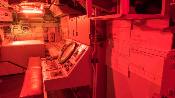 The interior of a military submarine illuminated with red lights