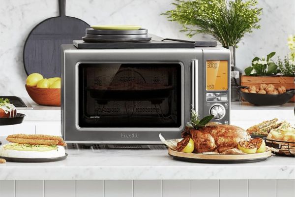 A Breville combination microwave displayed with various food items in a kitchen setting Credit: Amazon