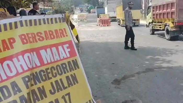 PENGECORAN - Petugas kepolisian mengatur lalu lintas di Jalan Lintas Timur Sumatra Palembang-Jambi, di Desa Talang Kepala, Kabupaten Banyuasin, Rabu (15/7/2026). Sedang ada pengecoran sehingga hingga membuat arus lalu lintas menjadi padat.