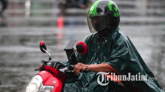 OJOL -- Pengemudi ojek online (ojol) berkendara di tengah hujan di kawasan Jalan Kartanegara, Kota Malang, Senin (19/5/2025). (Tribun Jatim Network/Purwanto)