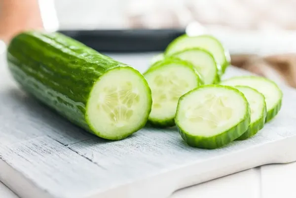 Ilustrasi timun atau mentimun Sliced fresh green cucumber on the cutting board.