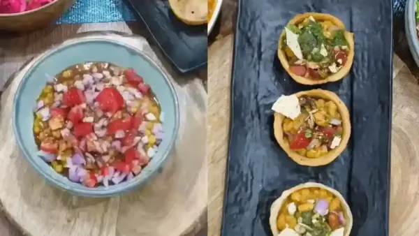Delicious crispy tart chaat filled with spicy chickpeas, tangy chutneys, fresh onions, and tomatoes served on black platter.
