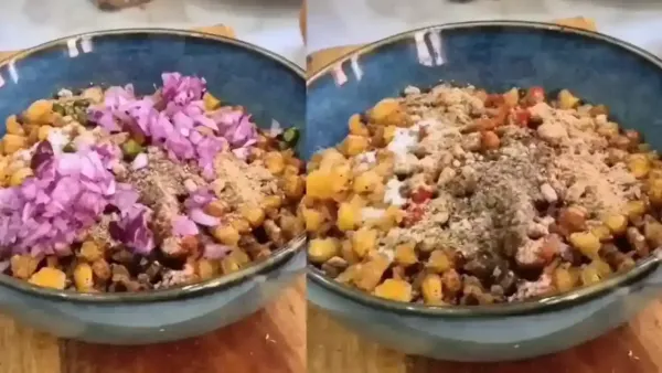 Freshly prepared sweet corn chaat topped with diced red onions and aromatic Indian spices in a blue bowl.