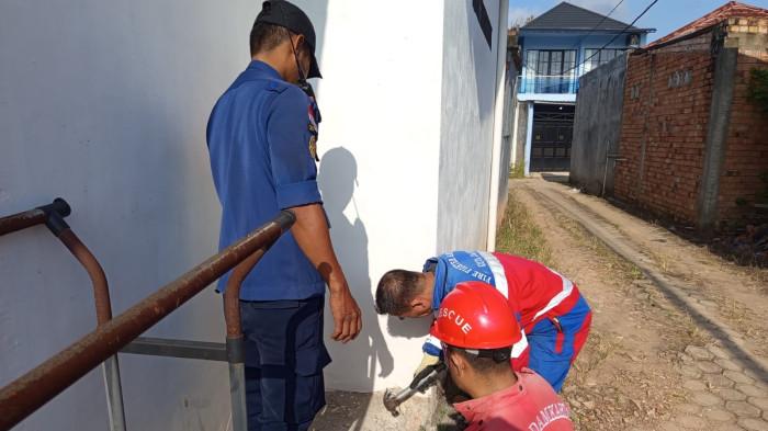 EVAKUASI - Damkartan Kota Jambi menjebol saluran pembuangan untuk menyelamatkan seekor kucing terjebak dalam pipa pembuangan. Peristiwa terjadi di rumah warga Jalan Yulius Usman, Kelurahan Pematang Sulur, Kecamatan Telanaipura, Jumat (17/7/2026) pagi.