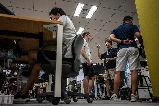 Government officials in casual dress code, including shorts, tee shirts and sneakers, work in the office of the Tokyo Metropolitan Government building, as part of the capitals 