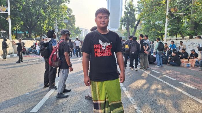 SIMBOL MERAKYAT - Wibisono Sinaga dari Serikat Tahanan Politik mengenakan sarung saat mengikuti aksi demonstrasi Mosi Tidak Percaya di kawasan Patung Kuda, Jakarta, Jumat (17/7/2026). Penggunaan sarung tersebut ia jadikan sebagai simbol semangat 'merakyat' dalam menentang kebijakan pemerintah.
