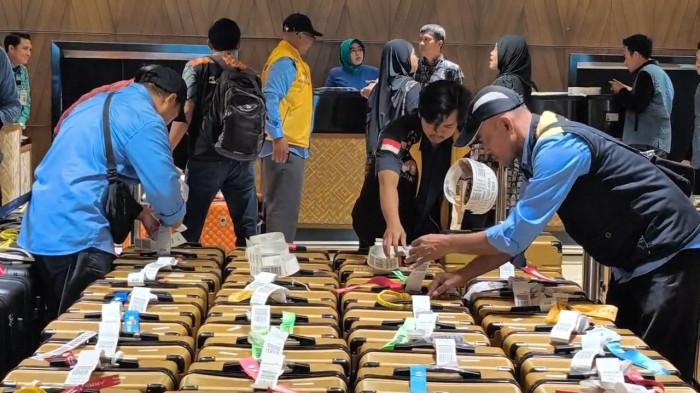 TERMINAL 2F - Petugas mengecek koper penumpang yang hendak berangkat menuju Tanah Suci Arab Saudi untuk menjalani ibadah umrah berangkat dari Terminal 2F Bandara Soekarno-Hatta, Benda, Kota Tangerang, Banten, Jumat (17/7/2026).