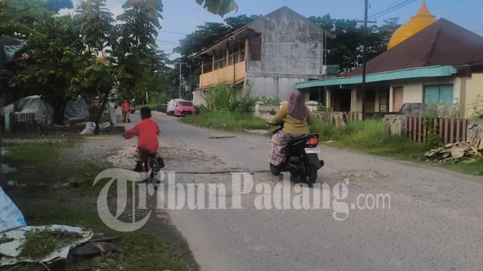 JALAN RUSAK- Pengendara sepeda dan motor melewati jalan yang rusak di kawasan Komplek PJKA, Kelurahan Sawahan Timur, Kota Padang, Sumatera Barat, Jumat (17/7/2026).