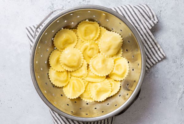 Ravioli draining in a colander on a striped towel Credit: Abbey Littlejohn