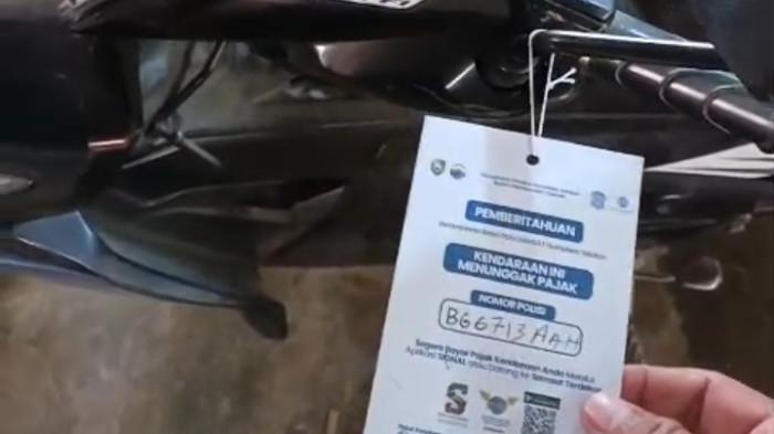 SURAT TUNGGAKAN PAJAK- Viral video yang memperlihatkan sejumlah sepeda motor digantungi surat pemberitahuan tunggakan Pajak Kendaraan Bermotor (PKB) oleh petugas Badan Pendapatan Daerah (Bapenda) Sumatera Selatan di Plaju Palembang, Jumat (18/7/2026).